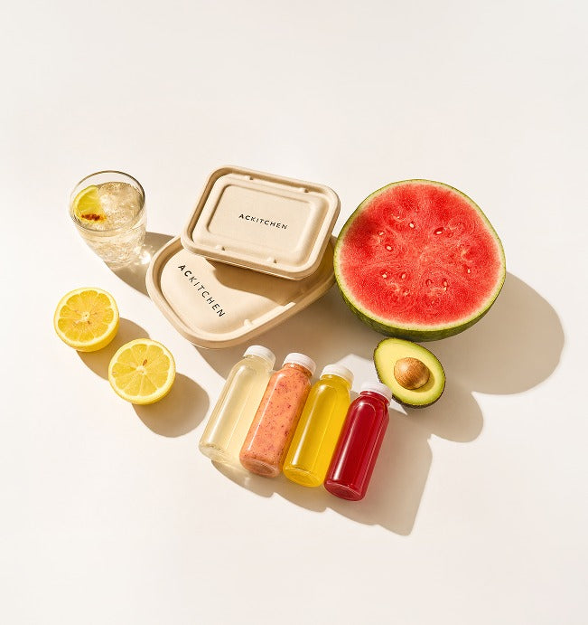 A week of Gut Reset meals, juices, and produce laid out on a table
